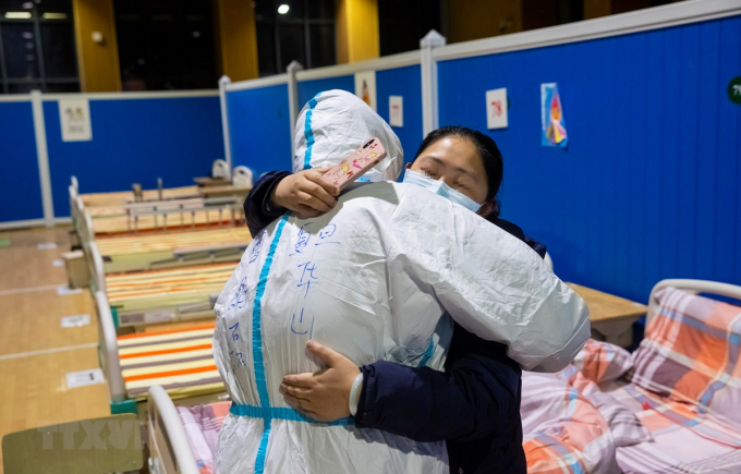 Bệnh nhân nhiễm COVID-19 tạm biệt bác sĩ sau khi được chữa khỏi tại bệnh viện ở Vũ Hán, tỉnh Hồ Bắc, Trung Quốc, ngày 9/3/2020. (Ảnh: THX/TTXVN)