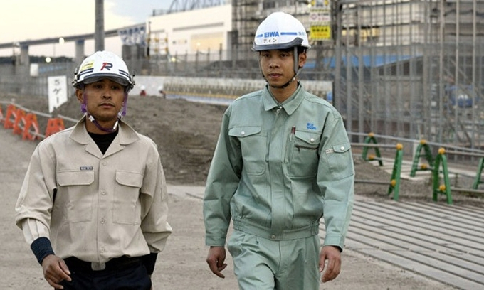 Dinh Van Duyet (phải), một công nhân xây dựng Việt Nam tại công trường thi đấu các môn thể thao dưới nước ở Tokyo năm 2018. Ảnh: Mainichi