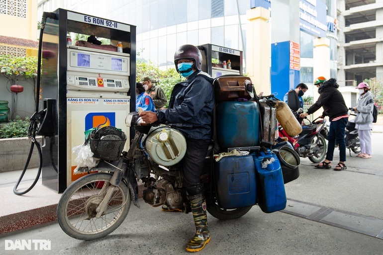 Một người dân mang theo rất nhiều can, thùng lớn đến một cây xăng tại Hà Đông để mua xăng, dầu trước giờ tăng giá (Ảnh: Hưng Phan).