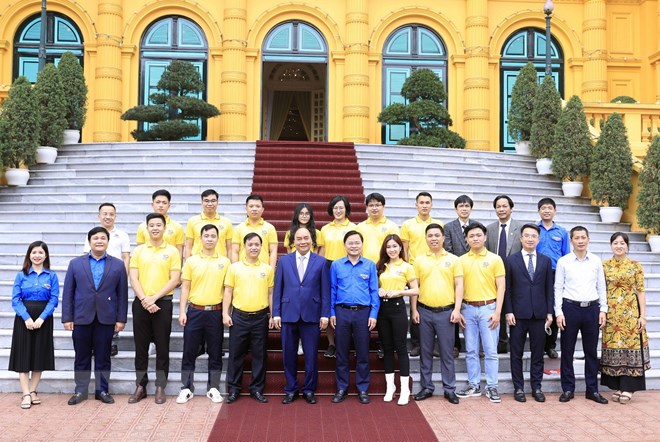 Chủ tịch nước Nguyễn Xuân Phúc chụp ảnh kỷ niệm cùng các gương mặt trẻ Việt Nam tiêu biểu năm 2021 - Ảnh: TTXVN