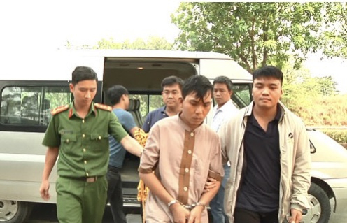 Đối tượng Nguyễn Văn Nghĩa được áp giải đến hiện trường đốt quần áo và phi tang hung khí sau khi gây án