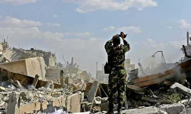 Một binh sỹ Syria kiểm tra một t&ograve;a nh&agrave; đổ n&aacute;t sau cuộc kh&ocirc;ng k&iacute;ch của Mỹ v&agrave; c&aacute;c nước đồng minh.