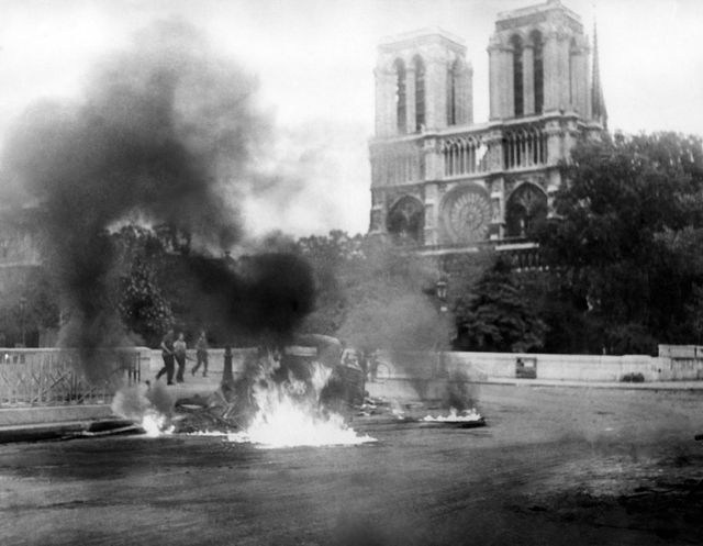 Xe bị đốt b&ecirc;n ngo&agrave;i Nh&agrave; thờ Đức B&agrave; Paris trong cuộc xung đột tại Ph&aacute;p năm 1944. (Ảnh: AFP)