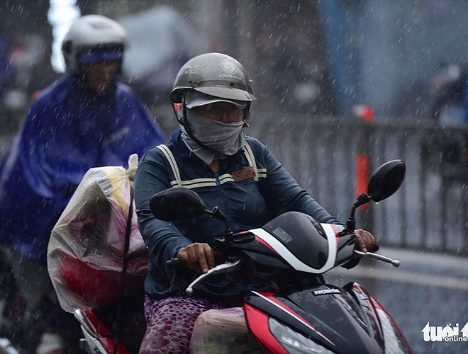 Người d&acirc;n chạy xe dưới trời mưa nặng hạt (nguồn: Tuổi Trẻ)
