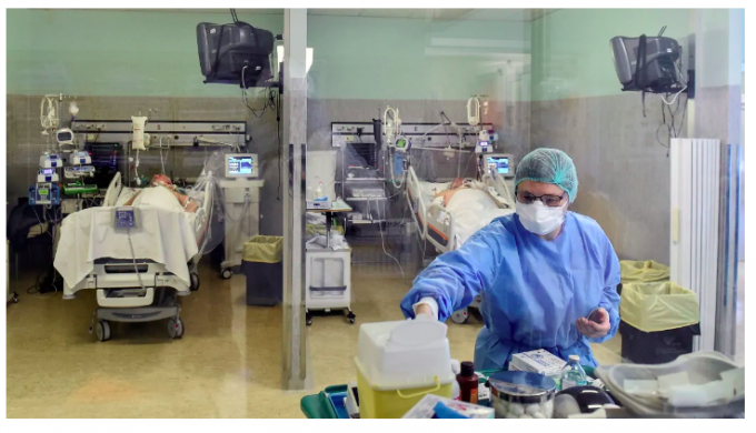 Một nhân viên y tế đeo khẩu trang bảo hộ và mặc bộ đồ điều trị cho bệnh nhân bị COVID-19 trong phòng chăm sóc đặc biệt tại một bệnh viện ở Cremona, Ý. (Flavio Lo Scalzo / Reuters)