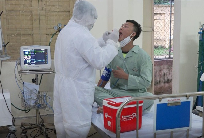 Trung tá, bác sĩ Nguyễn Đức Đồng thăm khám cho bệnh nhân nghi mắc COVID-19 Ảnh: PV