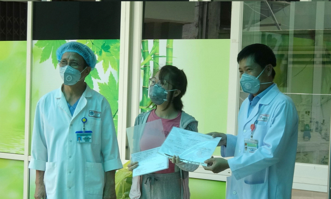 Lãnh đạo Bệnh viện Đà Nẵng trao giấy xuất viện cho bệnh nhân M. (ở giữa).