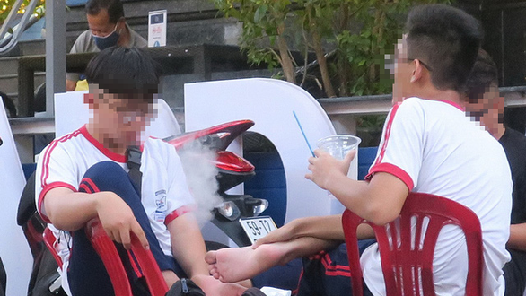 Học sinh một trường trung học hút thuốc lá điện tử tại một quán nước vỉa hè đường Lê Quý Đôn, quận 3, TP Hồ Chí Minh. (Ảnh: T.T.D.)