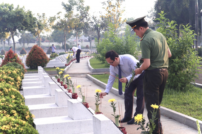 các đại biểu thắp hương, hoa tại các mộ liệt sĩ.