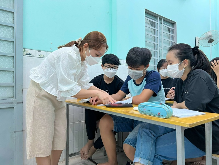 Cô giáo Hoàng Ngọc làm trợ giảng hỗ trợ thầy Khánh trong lớp học miễn phí (Ảnh: Diệp Phan).