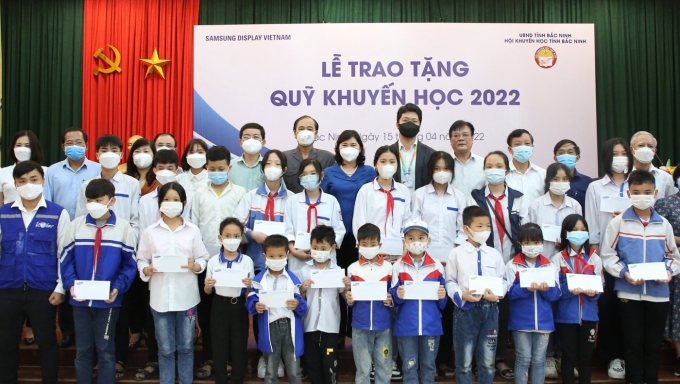 Các đồng chí lãnh đạo tỉnh, Hội Khuyến học tỉnh và Công ty TNHH Samsung Display Việt Nam chụp ảnh lưu niệm với các em học sinh.