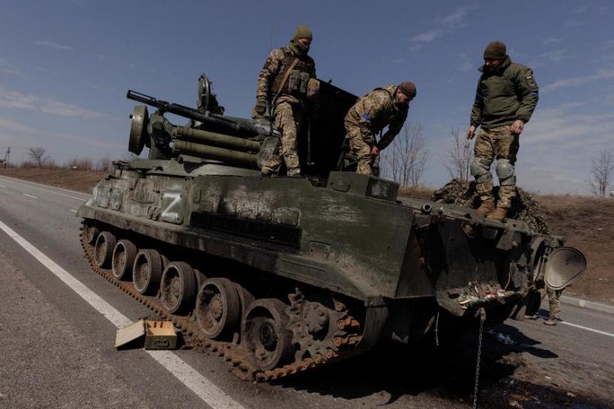 Binh sĩ Ukraine kiểm tra một chiếc xe quân sự Nga bị bắt giữ gần TP Kharkiv. Ảnh: Reuters