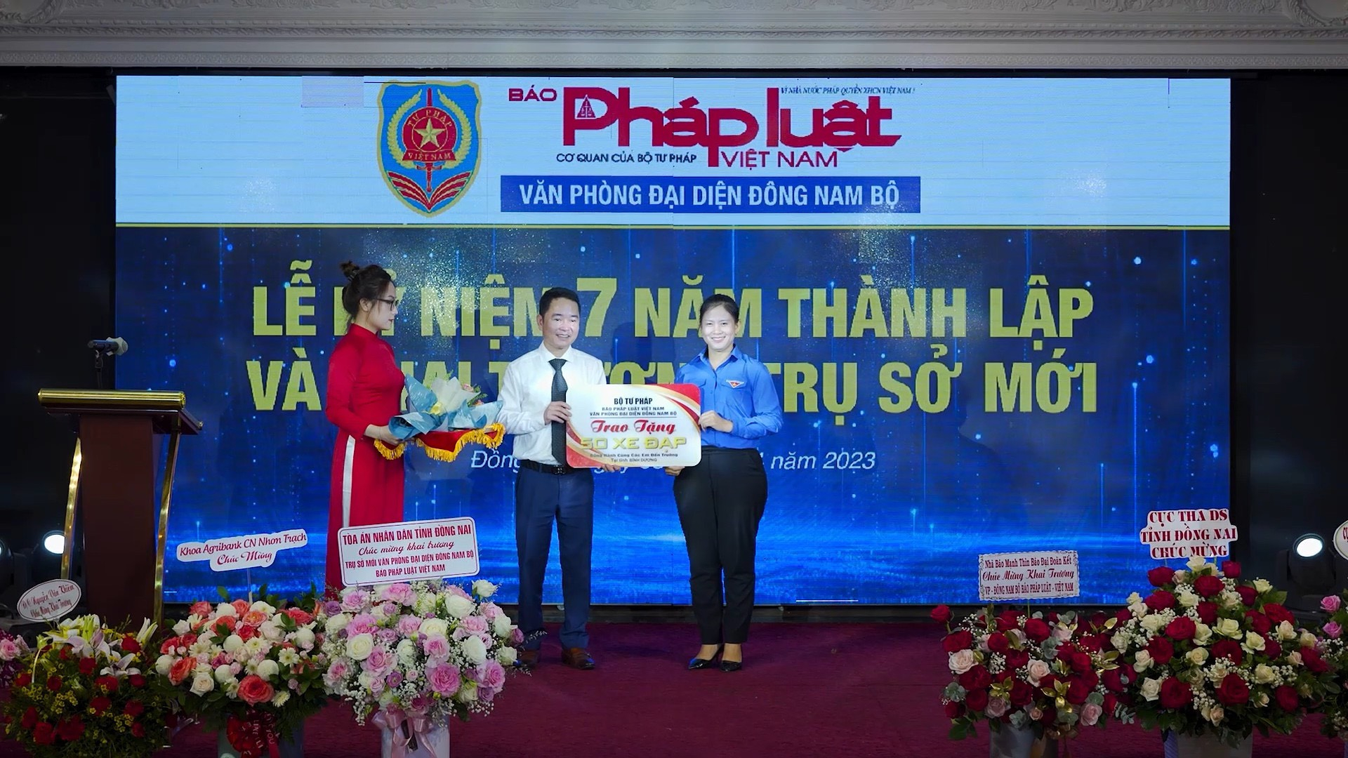 Ông Vũ Hoài Nam - Tổng Biên Tập Báo Pháp luật Việt Nam trao hoa và bảng vàng tặng 50 chiếc xe đạp trị cho đại diện tỉnh Bình Dương .