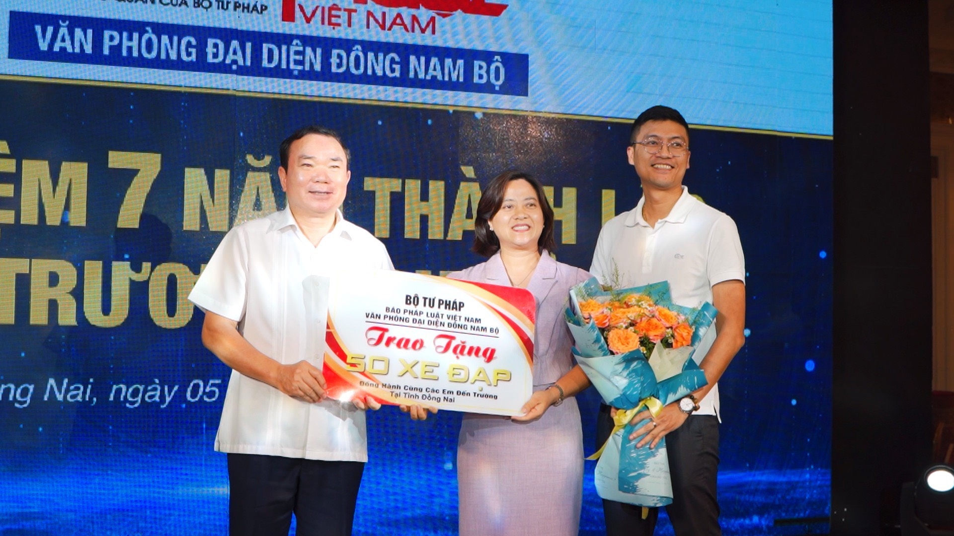 Ông Hà Ánh Bình- Phó Tổng Biên tập Báo Pháp luật Việt Nam trao hoa và bảng vàng tặng 50 chiếc xe đạp trị cho đại diện tỉnh Đồng Nai.