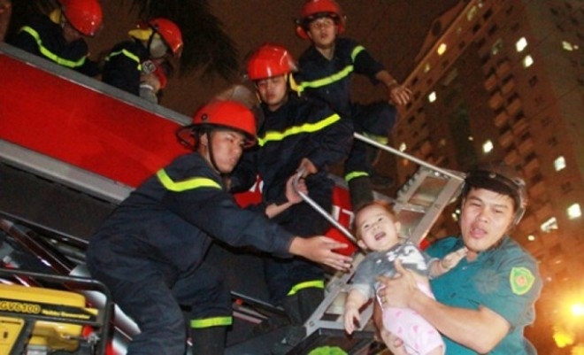 L&iacute;nh cứu hỏa đưa trẻ em từ t&ograve;a nh&agrave; CT4A xuống mặt đất bằng xe thang - Ảnh: PetroTimes.