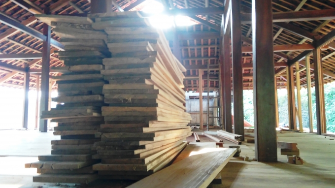 Một số lượng lớn gỗ được xếp vu&ocirc;ng vắn tr&ecirc;n mặt s&agrave;n.