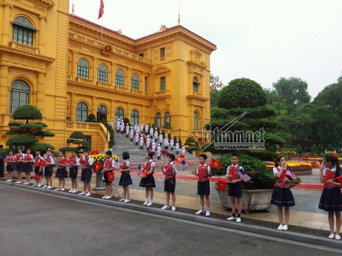 C&aacute;c em học sinh đang xếp h&agrave;ng tay cầm cờ Việt - Mỹ chuẩn bị đ&oacute;n kh&aacute;ch.