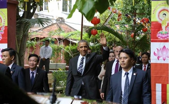 Tổng thống Obama mỉm cười, vẫy tay ch&agrave;o mọi người.