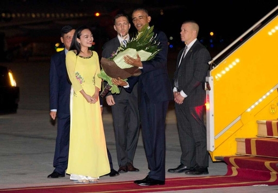 Tổng thống Mỹ Barack Obama được tặng hoa ngay khi đặt ch&acirc;n xuống s&acirc;n bay Nội B&agrave;i.&nbsp;(Ảnh: AP)