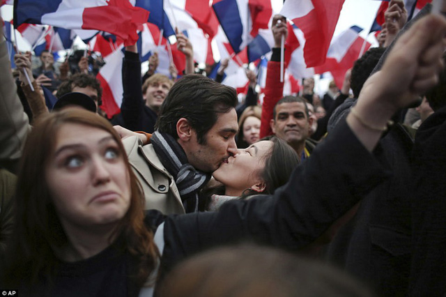 Một cặp đ&ocirc;i h&ocirc;n nhau khi ăn mừng chiến thắng của &ocirc;ng Macron. (Ảnh: AP)