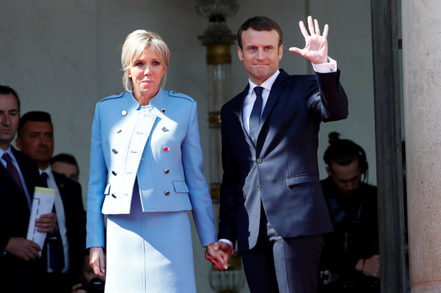 &Ocirc;ng Emmanuel Macron nắm tay phu nh&acirc;n Brigitte Trogneux khi vẫy ch&agrave;o người tiền nhiệm Francois Hollande sau cuộc chuyển giao quyền lực. (Ảnh: Reuters)