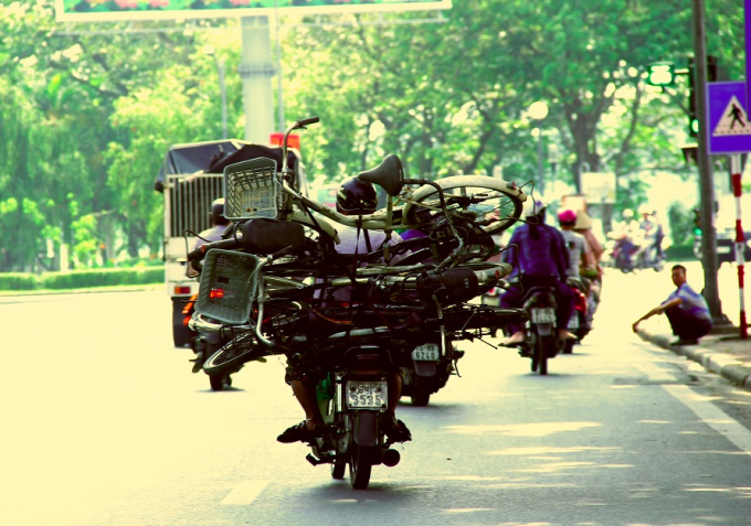 Điều khiển xe m&aacute;y chở th&ecirc;m nhiều chiếc xe đạp cồng kềnh tr&ecirc;n đường H&agrave; Nội (TP Huế).