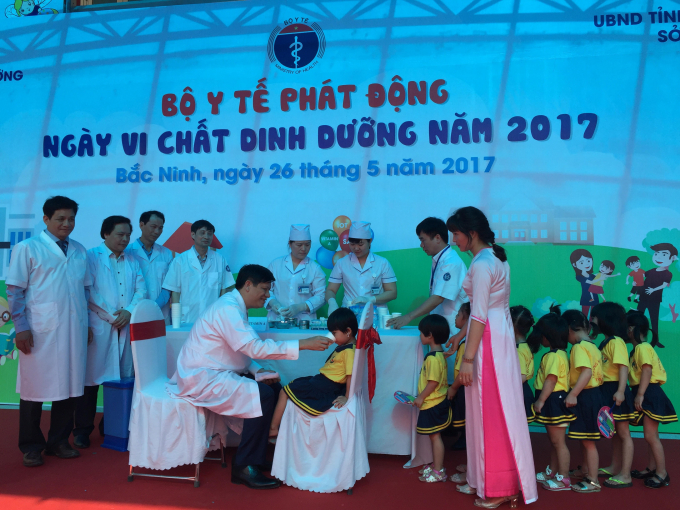 Thứ trưởng Bộ Y tế Nguyễn Thanh Long trực tiếp cho trẻ uống vitamin A tại lễ ph&aacute;t động.