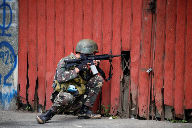 Một binh l&iacute;nh của qu&acirc;n đội ch&iacute;nh phủ đang theo d&otilde;i mục ti&ecirc;u từ một khe hở tại th&agrave;nh phố Marawi.