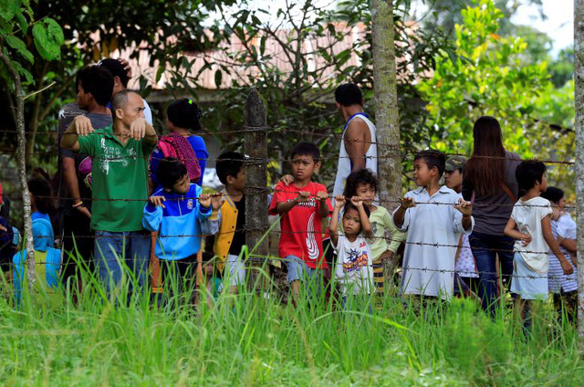 Những đứa trẻ đứng sau h&agrave;ng r&agrave;o d&acirc;y th&eacute;p gai khi đi sơ t&aacute;n tại Marawi.