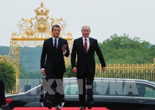 Tổng thống Emmanuel Macron (tr&aacute;i) v&agrave; Tổng thống Putin (phải) tại lễ đ&oacute;n ở Paris. Ảnh: AFP/TTXVN
