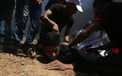 Người Palestine bị thương do tr&uacute;ng đạn ph&aacute;o từ lực lượng an ninh Israel. Ảnh: Reuters