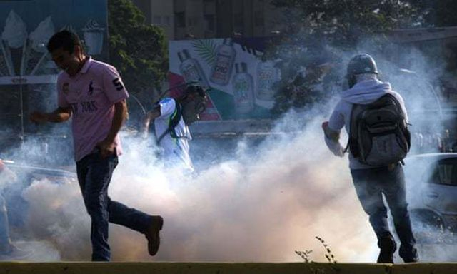 Người biểu t&igrave;nh đụng độ với lực lượng an ninh ở Caracas. (Ảnh: AFP)
