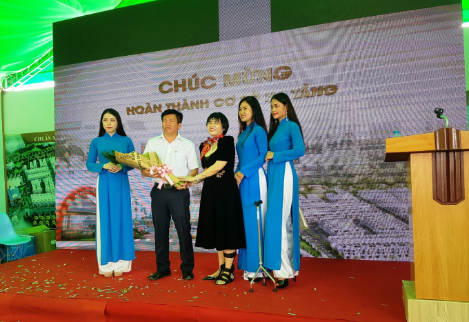 Bà Phạm Thị Hường (áo đen, ở giữa) tặng hoa cảm ơn ông Nguyễn Thanh Tâm – Chủ tịch UBND TX Thuận An.