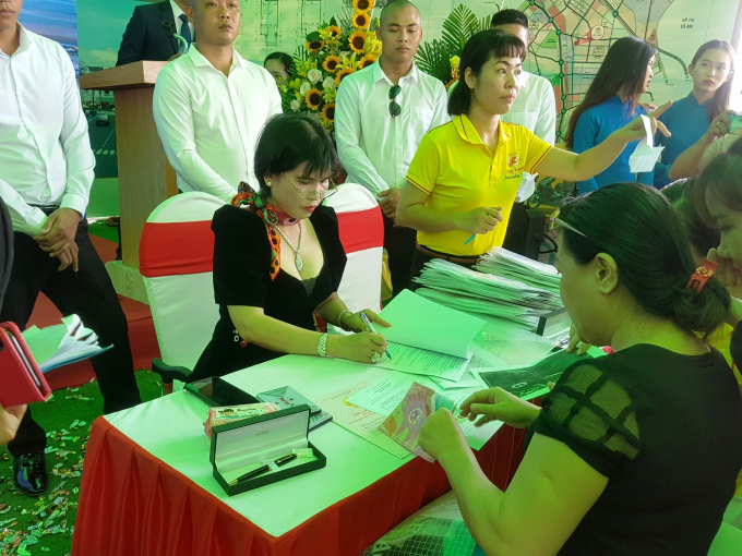 Bà Phạm Thị Hường (váy đen, bên trái ảnh), đại diện chủ đầu tư và khách hàng ký hợp đồng, bàn giao sổ hồng.
