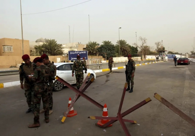 Lực lượng an ninh tập hợp ở một cổng kiểm tra dẫn vào vùng Xanh ở Baghdad. Ảnh: Reuters