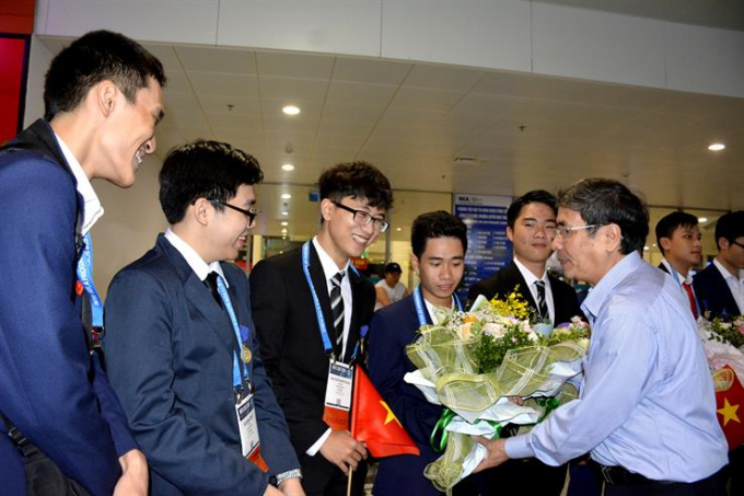 Ông Vũ Đình Chuẩn, Vụ trưởng Vụ GD Trung học (Bộ GD&amp;amp;ĐT) tặng hoa chúc mừng đoàn học sinh Việt Nam tham dự Intel ISEF 2019 trở về. Ảnh: Bộ GD &amp;amp; ĐT cung cấp.