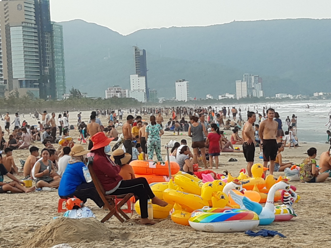 Chiều 1/5, người dân và du khách có mặt đông đảo tại bãi tắm trên đường Võ Nguyên Giáp, quận Sơn Trà, TP Đà Nẵng để nghỉ ngơi, du lịch trong 4 ngày nghỉ lễ.