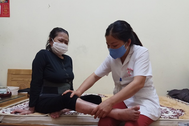 Chị Nguyễn Thị Thiêm - Nhân viên y tế Trung tâm Nuôi dưỡng và điều dưỡng người có công số 2 đang xoa bóp cho bà Vương Thị Là - cựu thanh niên xuong phong. Ảnh: Trần Oanh