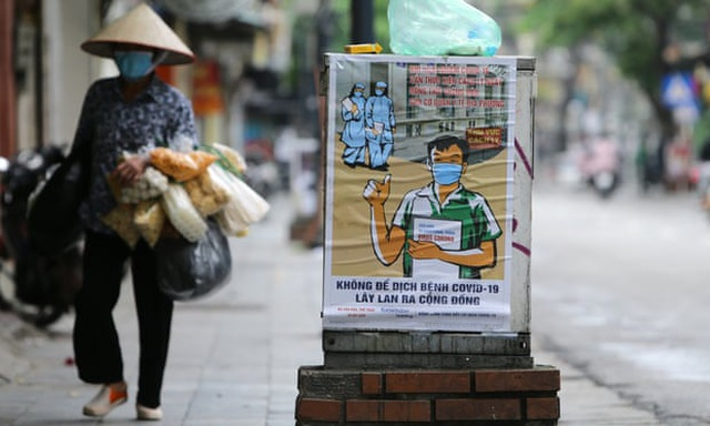 Tranh tuyên truyền về dịch Covid-19 trên đường phố Hà Nội.(Ảnh: Luong Thai Linh/EPA)