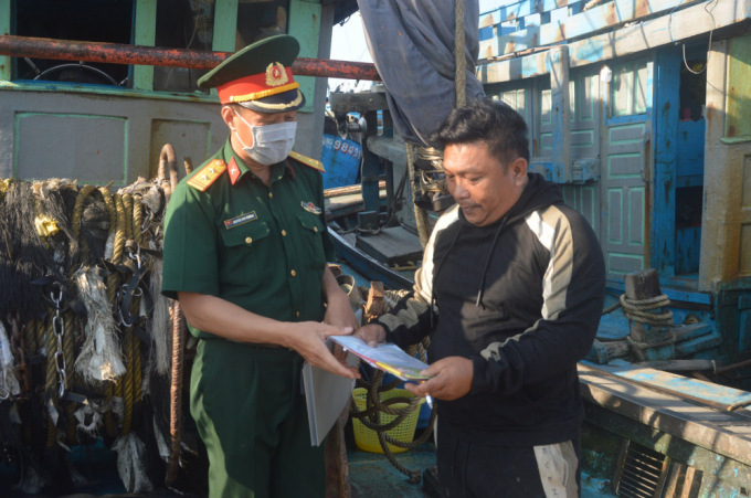 Bộ đội Biên phòng phát tờ rơi tuyên truyền về bầu cử cho ngư dân đánh bắt xa bờ trên huyện đảo.