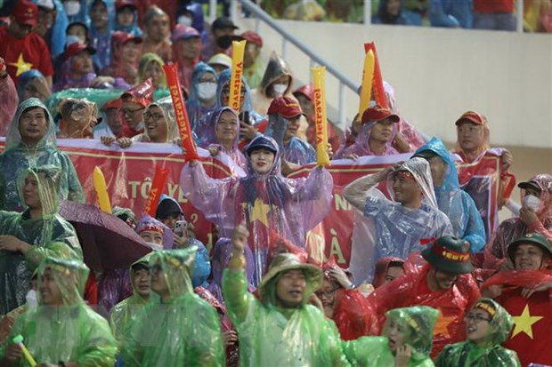 Cổ động viên Việt Nam đội mưa cổ vũ cho các cầu thủ đội U23 Việt Nam. (Ảnh: Minh Quyết/TTXVN)