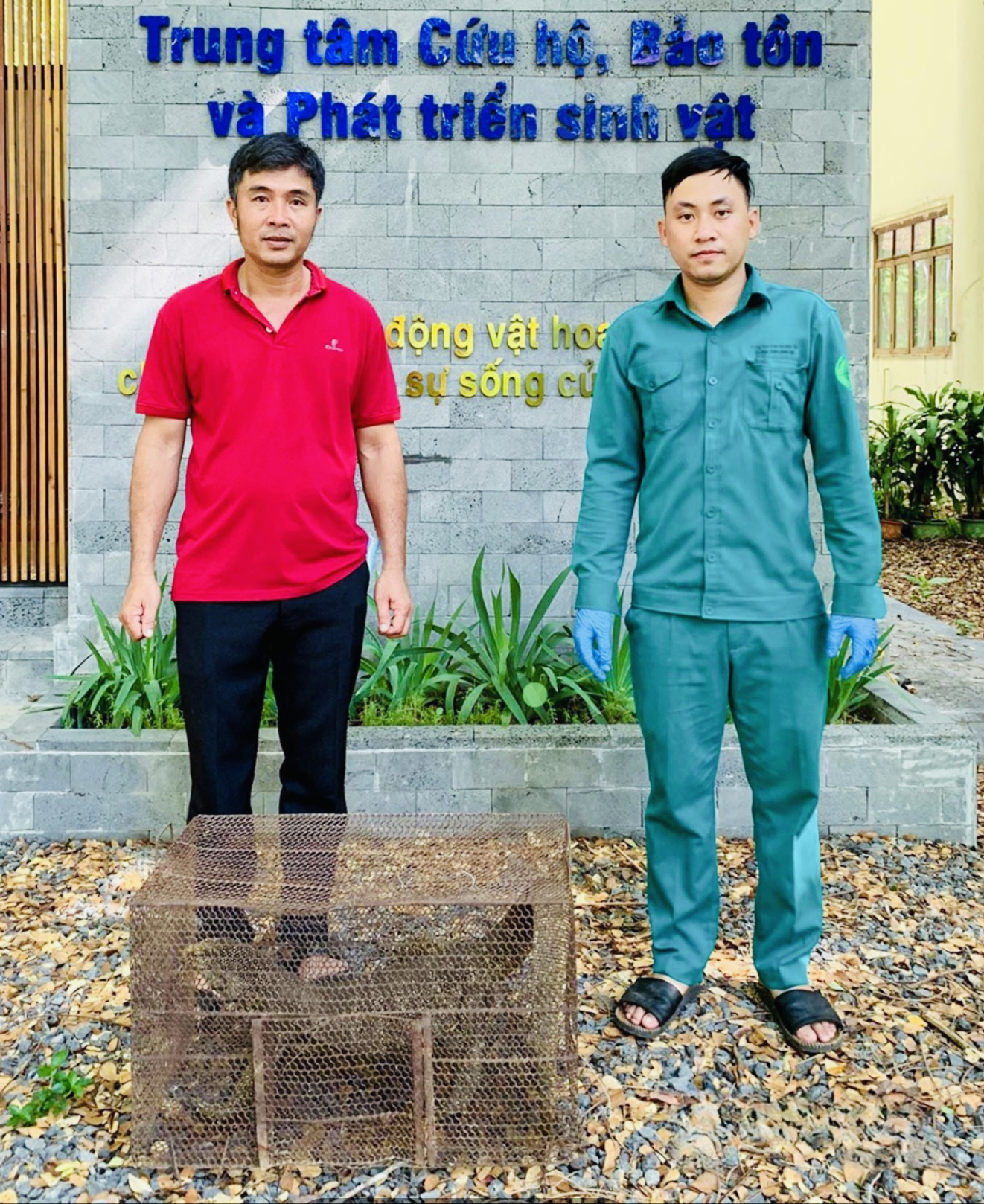 Anh Nguyễn Văn Minh (trái) bàn giao cá thể kỳ đà cho đơn vị cứu hộ động vật. (Ảnh: Báo Đồng Nai)