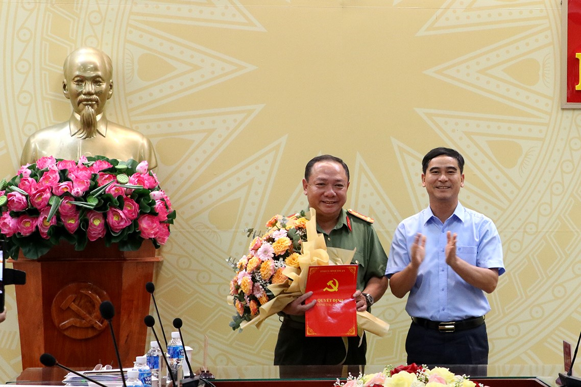Bí thư Tỉnh ủy Bình Thuận Dương Văn An trao quyết định và tặng hoa chúc mừng Đại tá Lê Quang Nhân. (Ảnh: TTDân)
