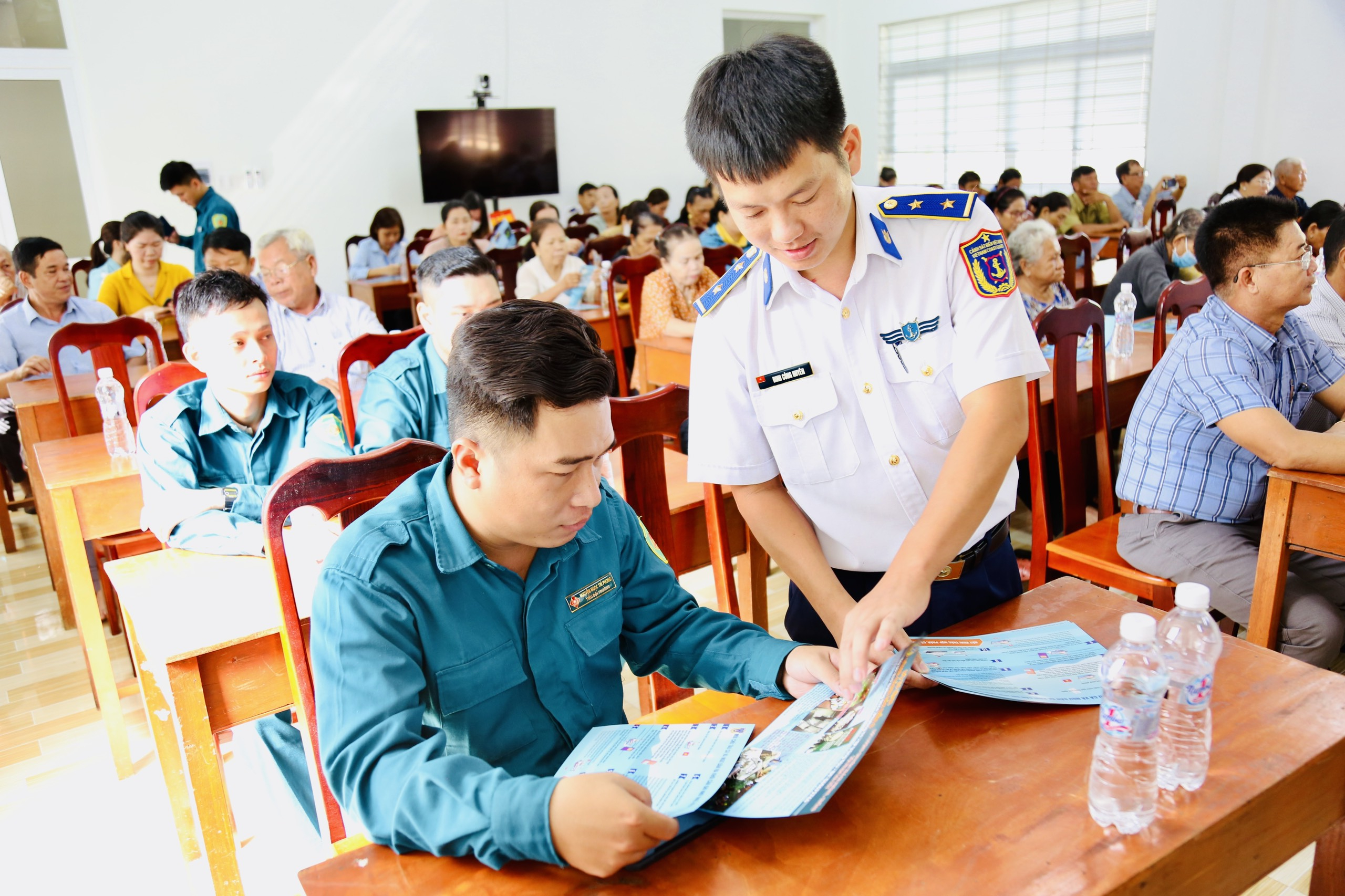 Cán bộ của Bộ Tư lệnh Vùng Cảnh sát biển 3, phát tờ rơi tuyên truyền tại hội nghị.