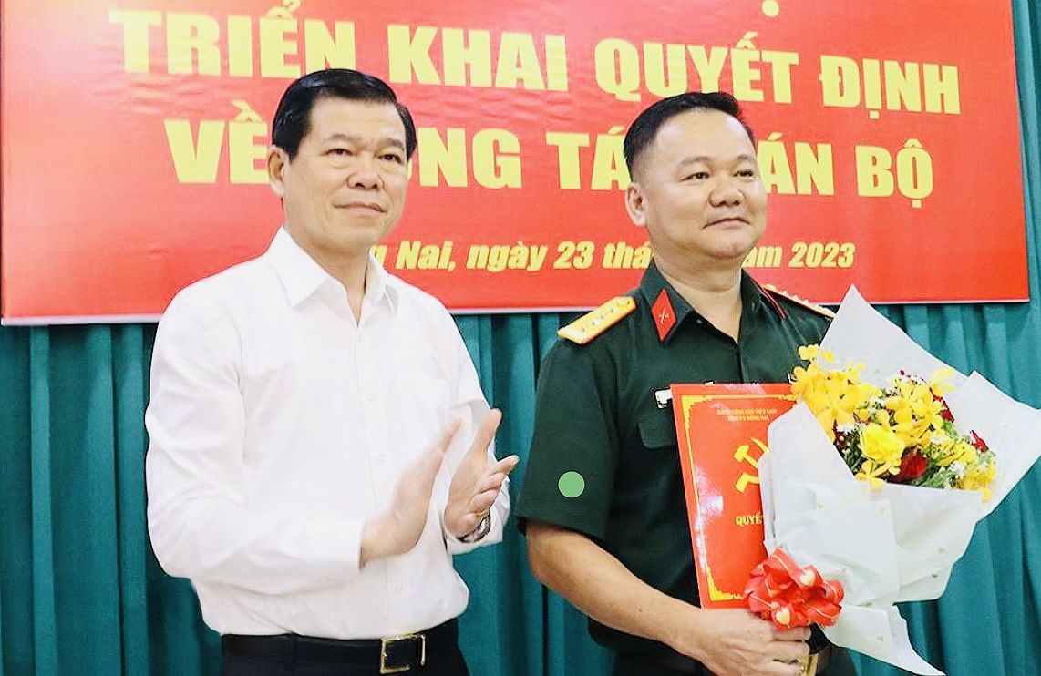 Bí thư Tỉnh ủy Nguyễn Hồng Lĩnh trao quyết định và tặng hoa cho Đại tá Bùi Đăng Ninh (ảnh: N.H).