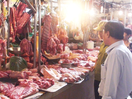 Ban quản l&yacute; chợ Bi&ecirc;n H&ograve;a kiểm tra chất lượng thịt heo được b&agrave;y b&aacute;n tại sạp. Ảnh: D.Linh