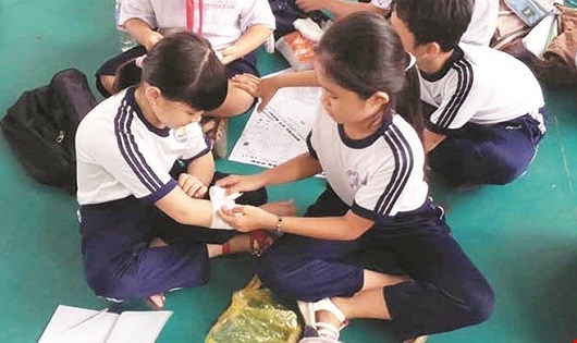 Trẻ học thực h&agrave;nh kỹ năng sơ cứu khi bị thương.