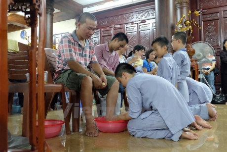 Lần đầu được rửa ch&acirc;n cho cha mẹ. (Ảnh: Dương Phạm/Vietnam+)