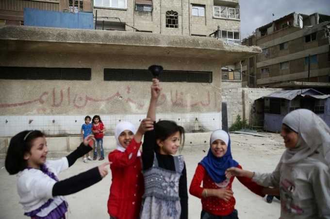 C&aacute;c b&eacute; g&aacute;i rung chu&ocirc;ng trong s&acirc;n trường ở thị trấn Douma. &nbsp;(Ảnh: Reuters)