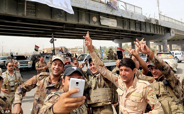 Lực lượng qu&acirc;n đội Iraq chụp ảnh ăn mừng chiến thắng. (Ảnh: AP)